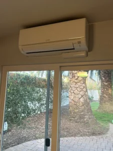 An exterior view of a home featuring a window air conditioner mounted